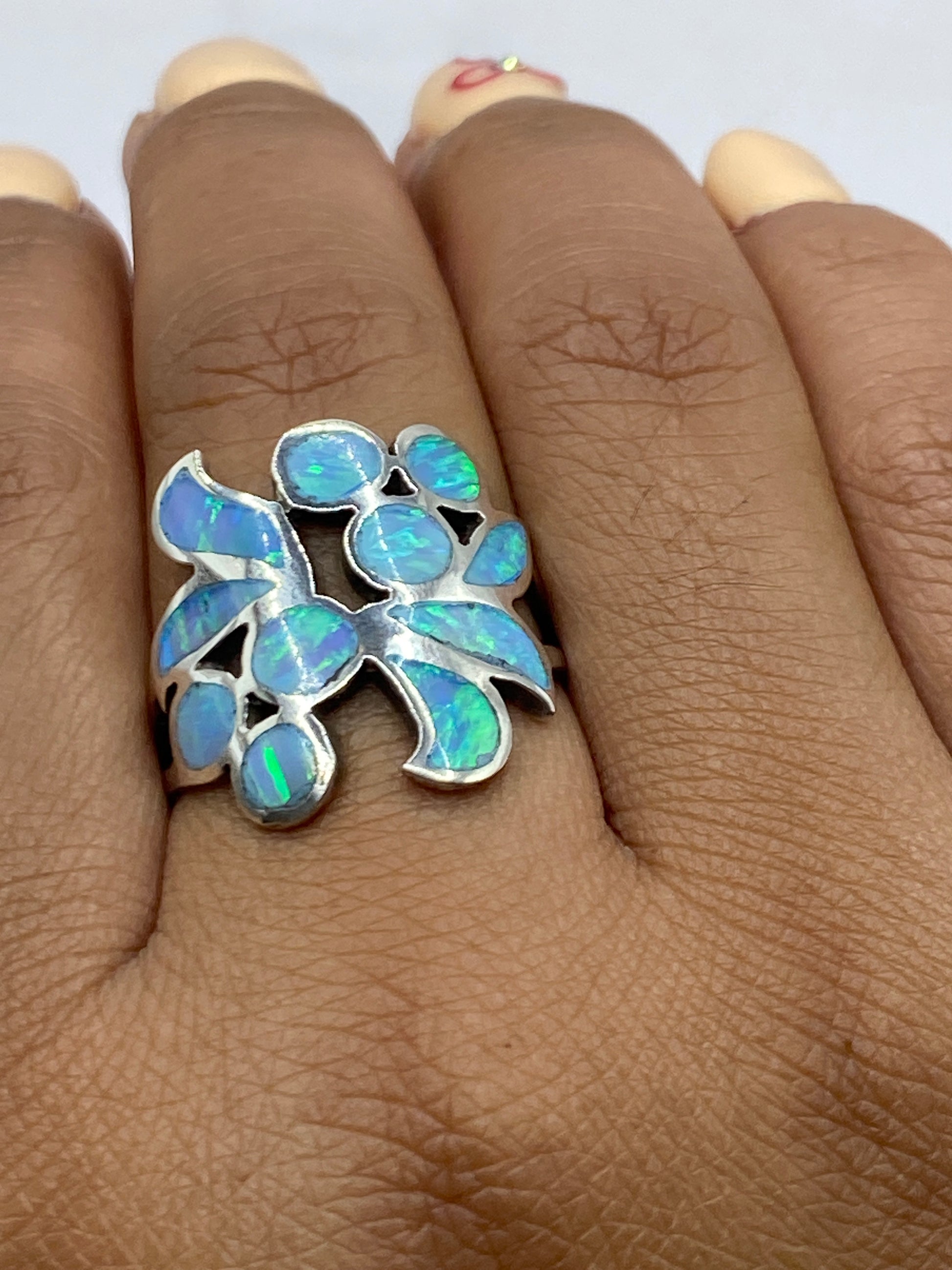 Anillo en la mano mostrando cómo brilla el ópalo de fuego con movimiento