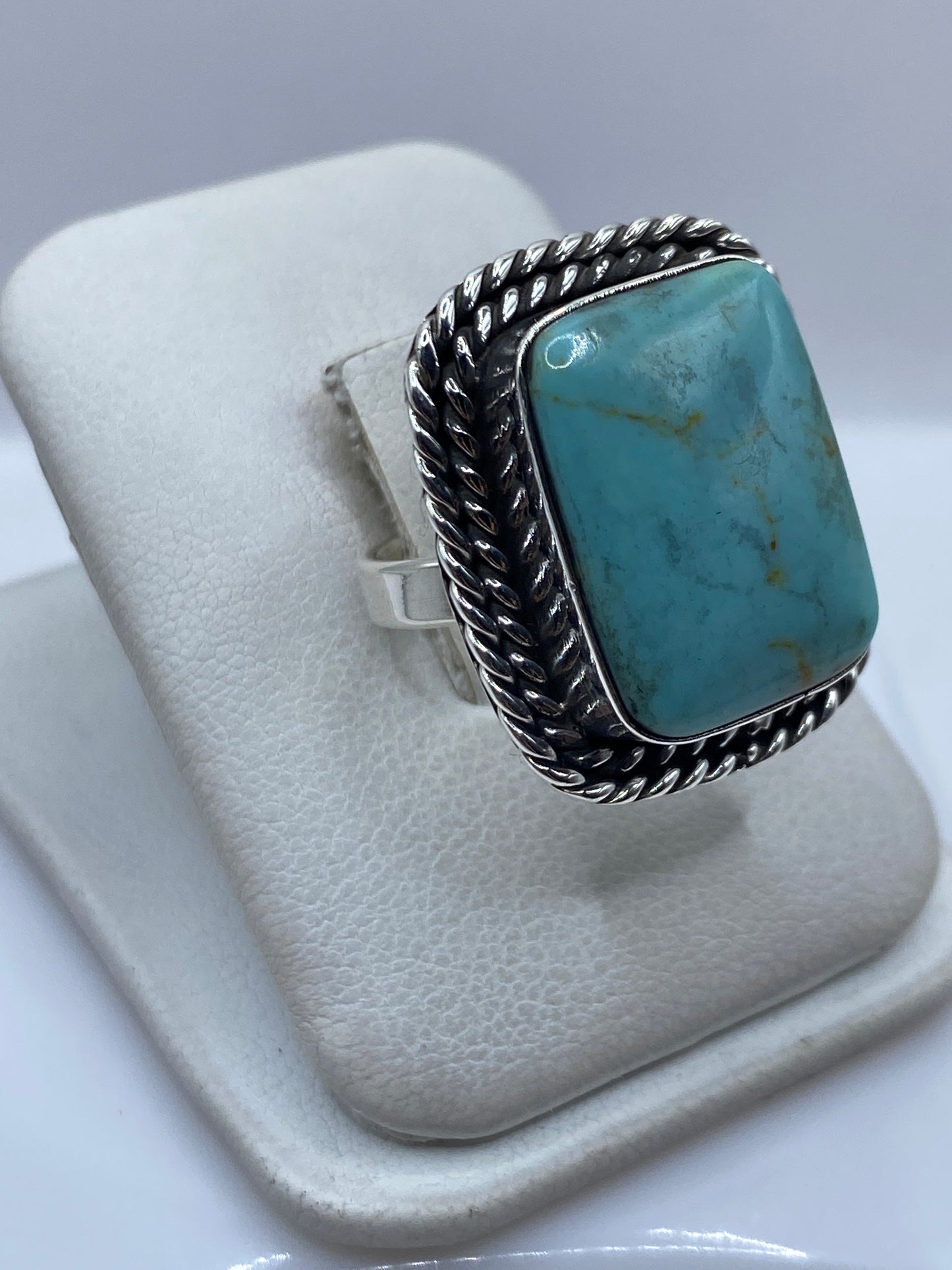 Detalle lateral del anillo mostrando el engaste a mano de la turquesa en plata .925