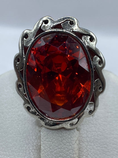 Detalle del engaste y la circonia roja brillante, anillo sobre fondo blanco