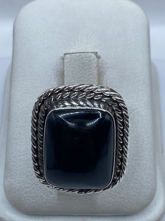 Anillo de plata .925 con ónix negro y marco retorcido, en estuche de presentación