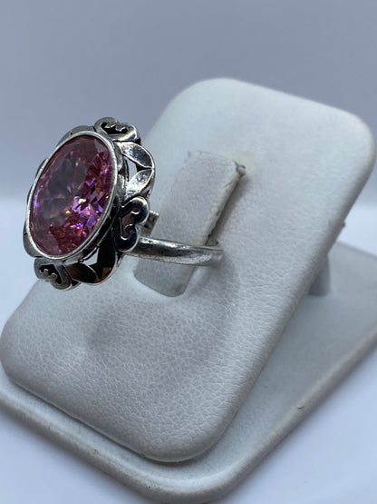 Anillo de plata con circonia rosa en el dedo, mostrando el brillo de la piedra