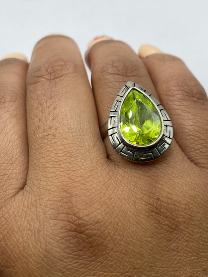 Anillo en dedo: circonia verde brillante mostrando reflejos de luz