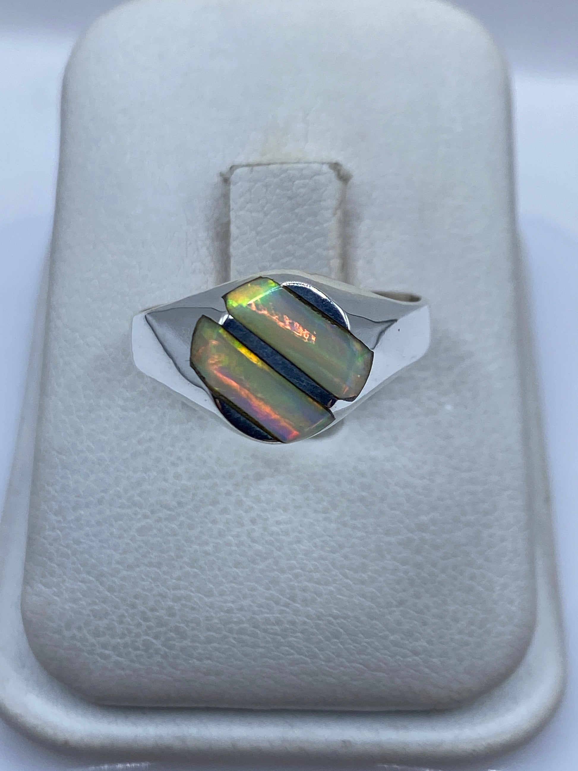 Anillo de plata .950 con ópalo de fuego iridiscente en la mano de una mujer