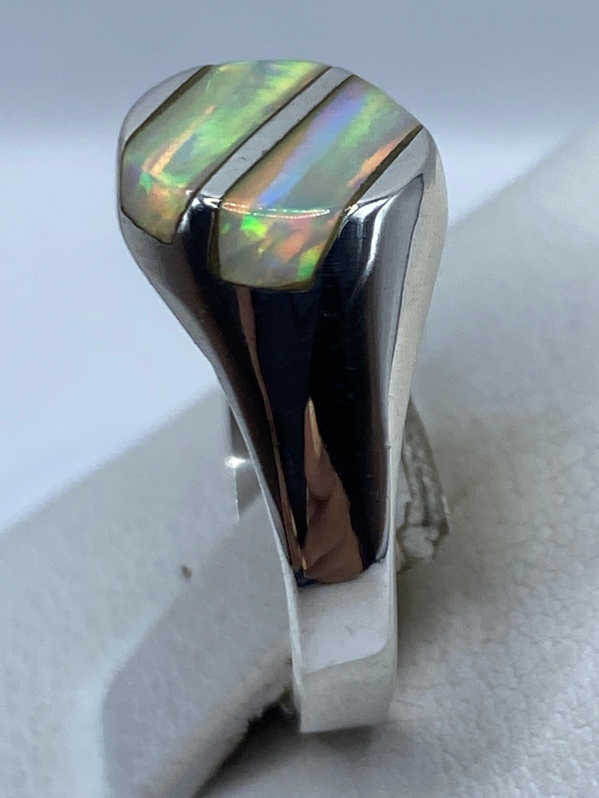 Vista lateral del anillo en plata pulida con ópalo engastado a mano