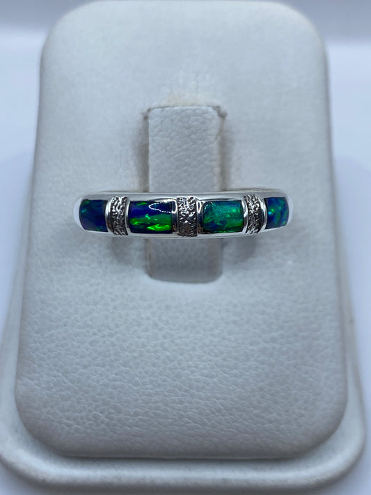 Anillo de plata .950 con ópalo de fuego azul engastado, visto de frente en la mano