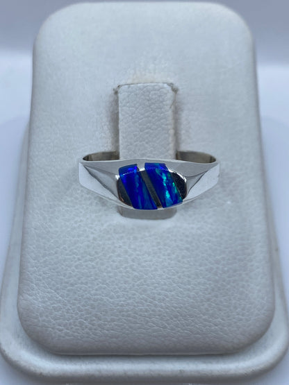 Anillo de plata .925 con ópalo de fuego azul en forma de escudo sobre anillo de algodón blanco