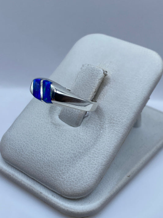 Vista lateral del anillo minimalista de plata con ópalo azul engastado