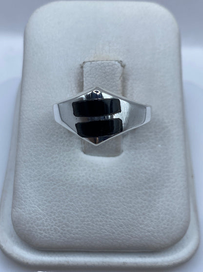 Anillo de plata con ónix negro en forma hexagonal sobre fondo blanco