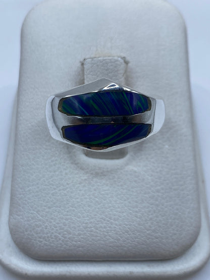 Anillo de plata con piedra azul engastada en diseño moderno, vista frontal