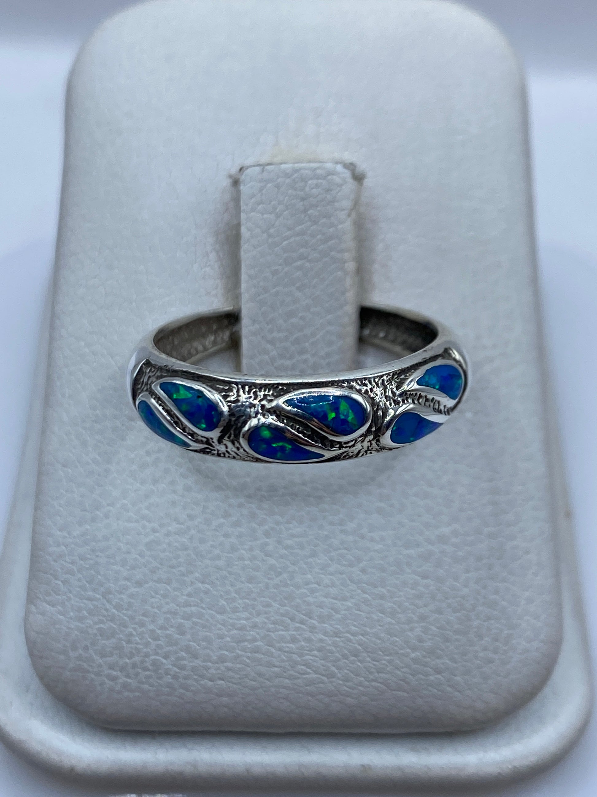 Anillo de plata .950 con ópalo de fuego azul engastado, sobre dedo de mujer