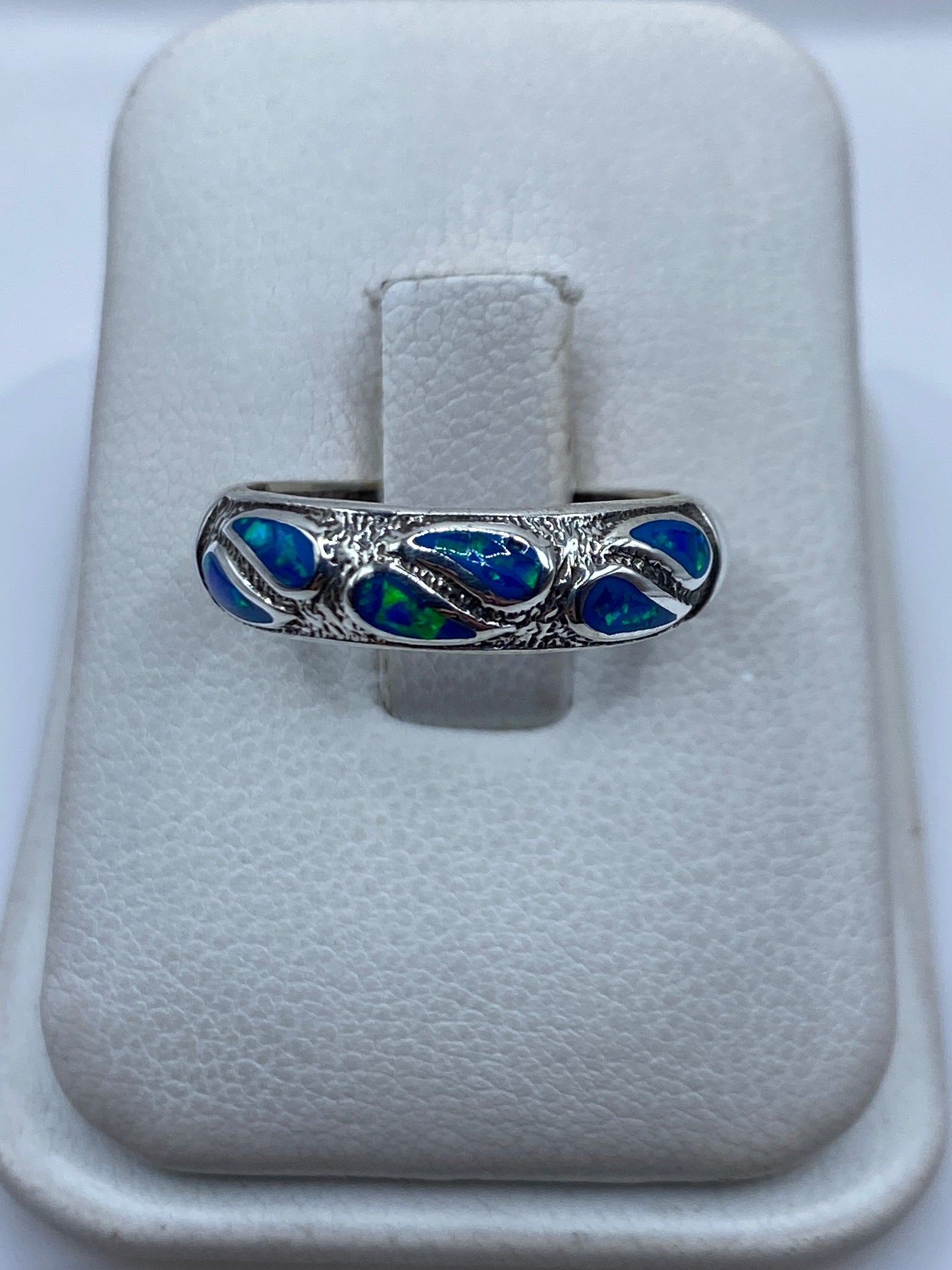 Anillo de plata .950 con ópalo de fuego azul engastado a mano, sobre estuche blanco