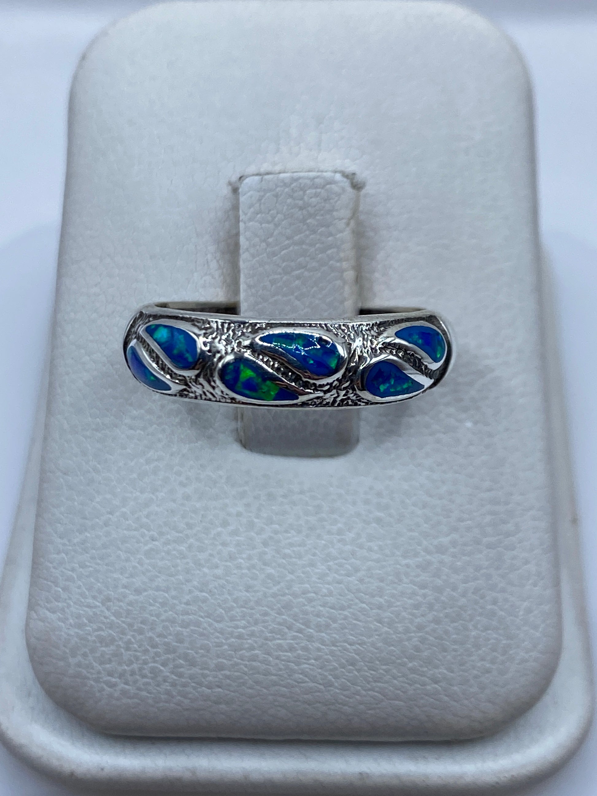 Anillo de plata .950 con ópalo de fuego azul engastado a mano, sobre estuche blanco