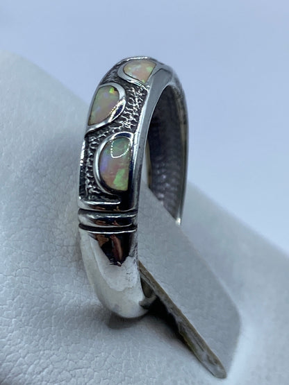Opalo de Fuego iridiscente en el dedo, visto de frente bajo luz natural