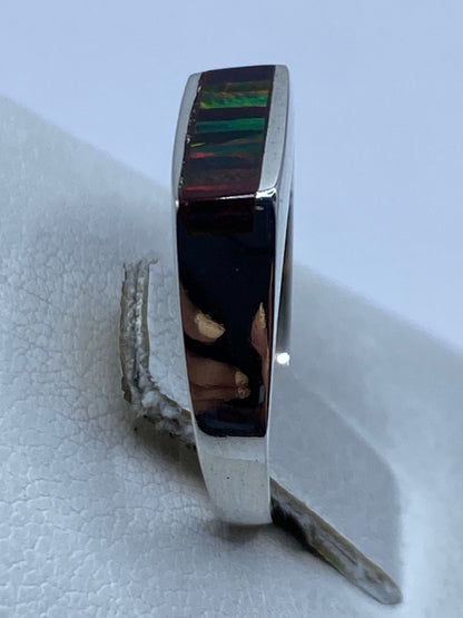 Anillo en la mano mostrando el juego de luz del ópalo y el acabado pulido de la plata .950