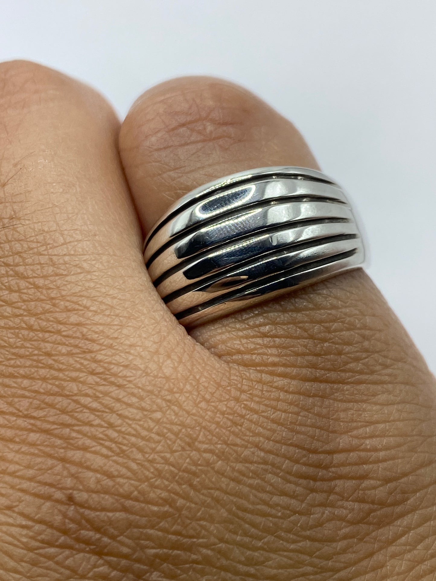 Anillo sobre fondo blanco destacando las líneas paralelas y el acabado brillante