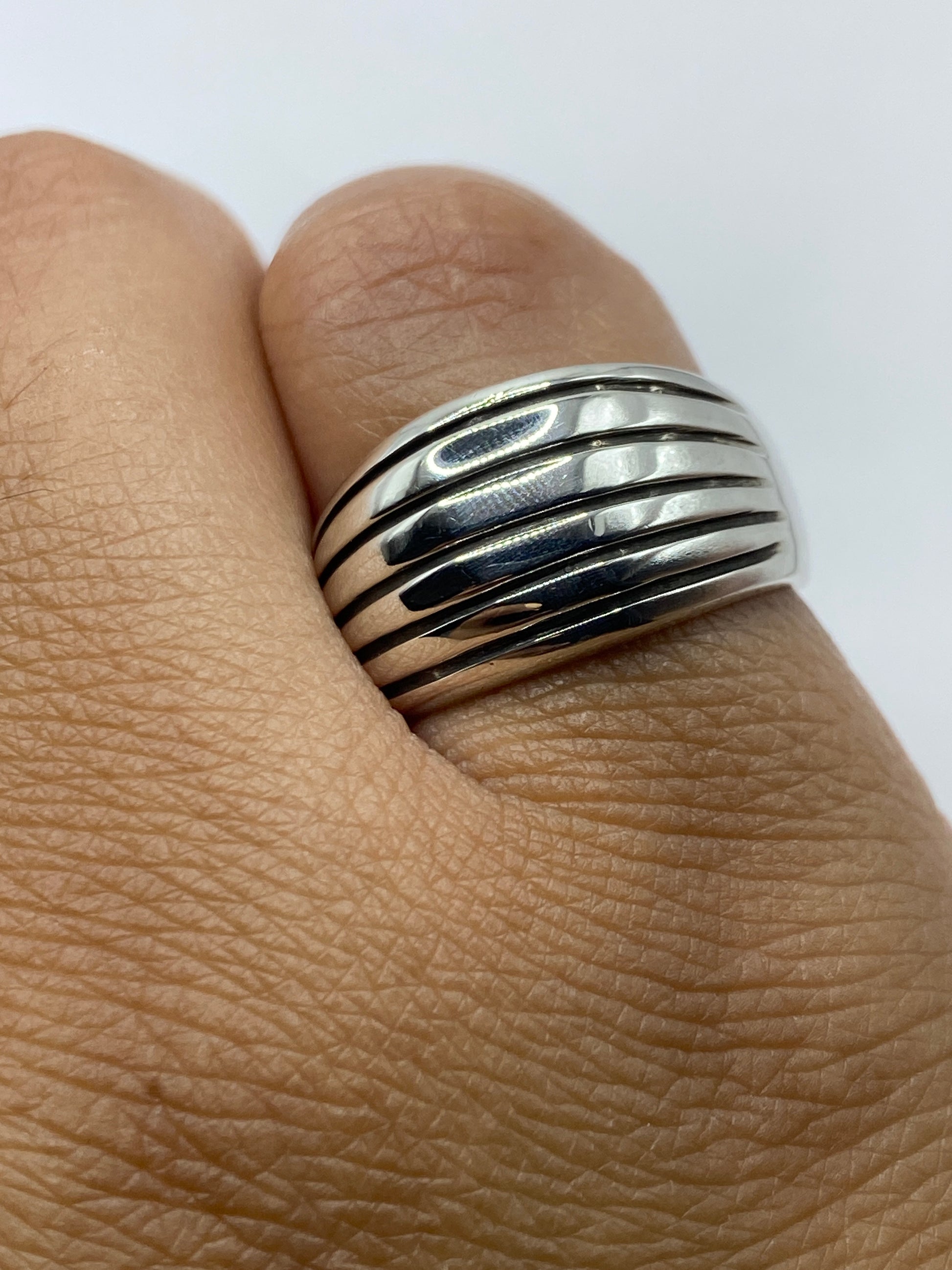 Anillo sobre fondo blanco destacando las líneas paralelas y el acabado brillante