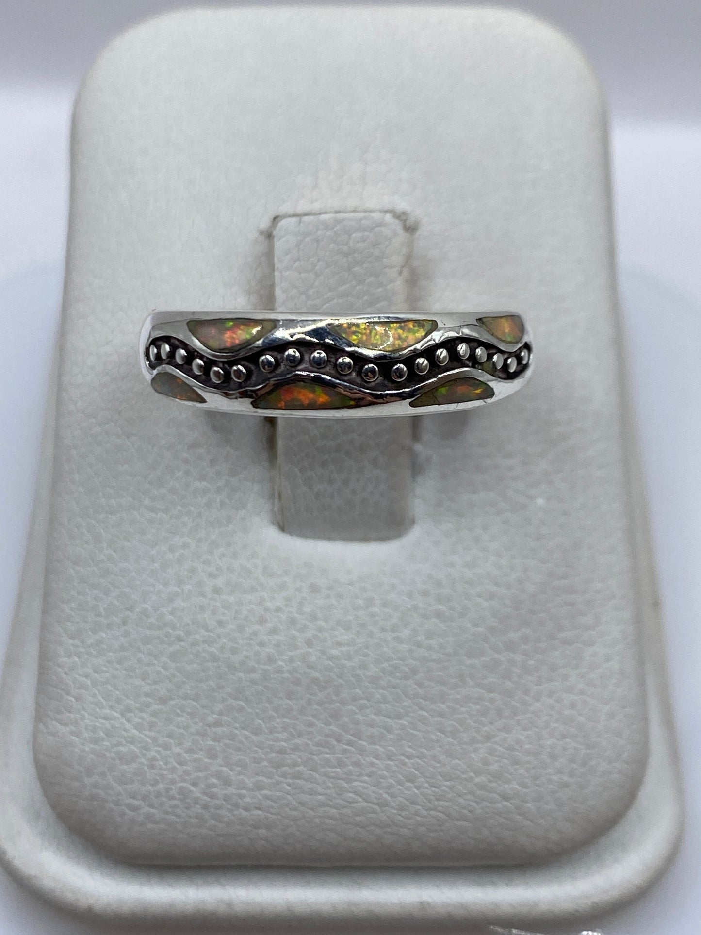 Anillo de plata .950 con ópalo de fuego amarillo en vaina de granulados, visto desde arriba en estuche blanco