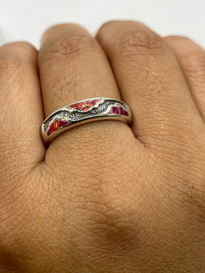 Anillo en mano mostrando la belleza del ópalo en color rosa coral