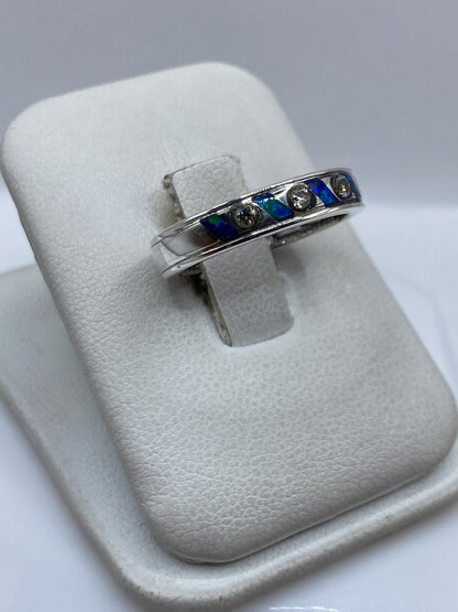 Vista frontal del anillo mostrando el ópalo azul y los tres puntos de engaste en plata
