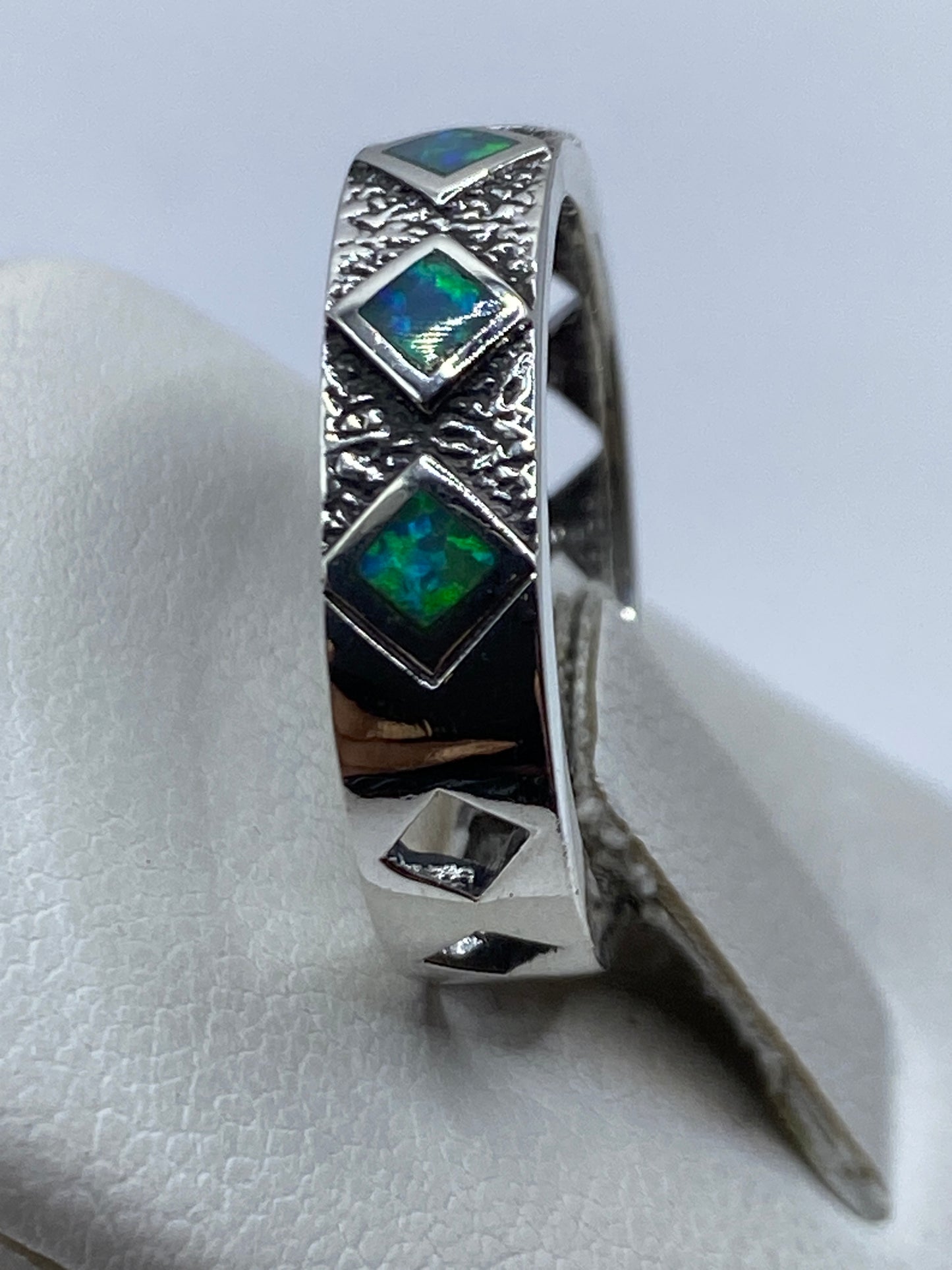Anillo puesto en dedo, mostrando la técnica combinada y el engaste de la piedra