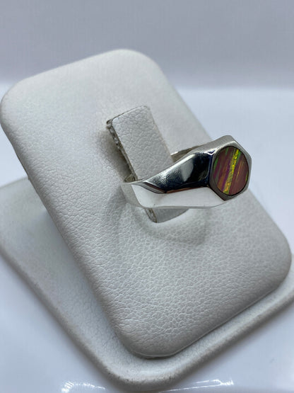 Lateral del anillo minimalista mostrando el engaste de ópalo y los costados de plata pulida