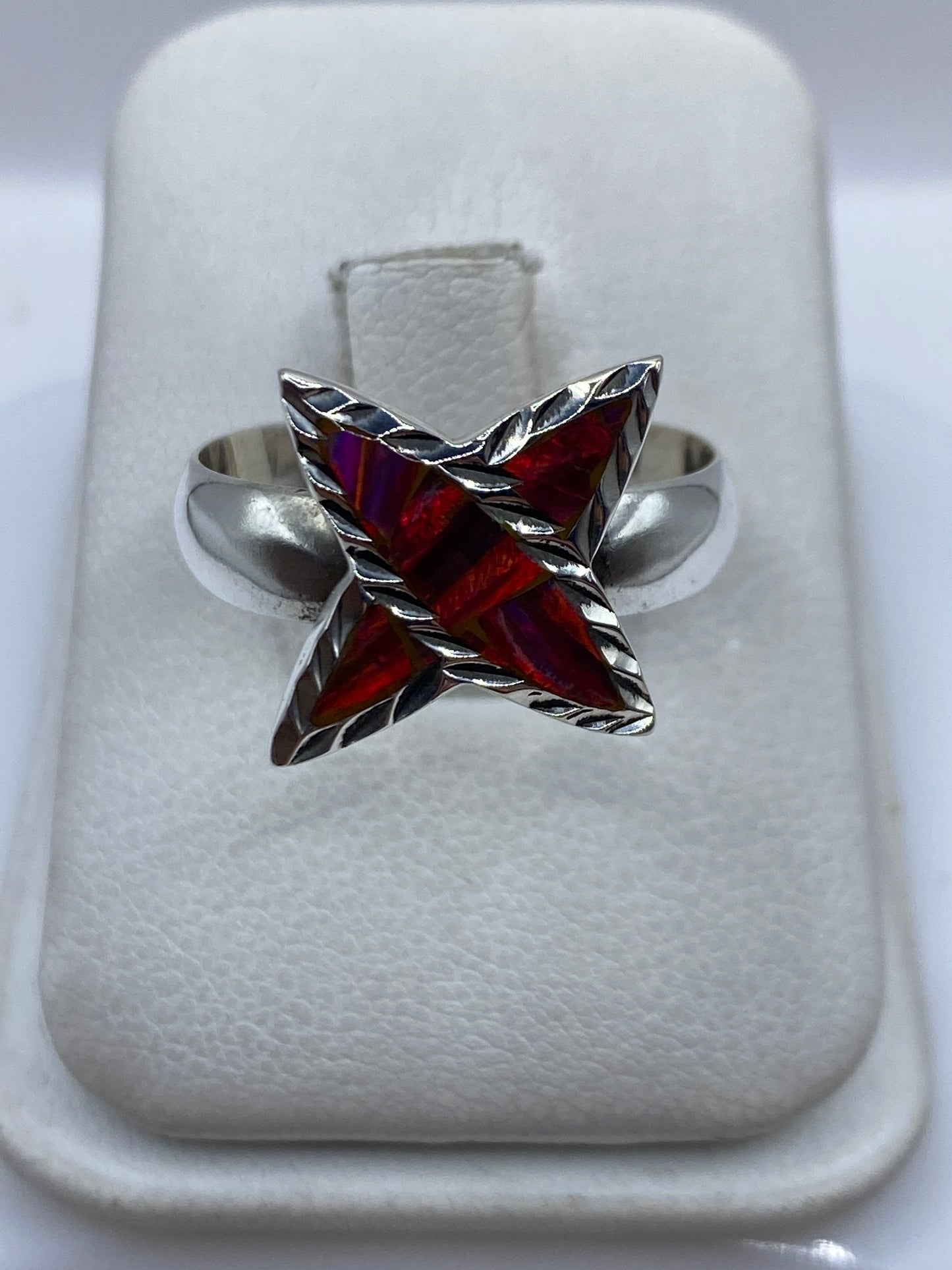 Anillo de plata con ópalo de fuego multicolor engastado a mano, vista frontal sobre dedo