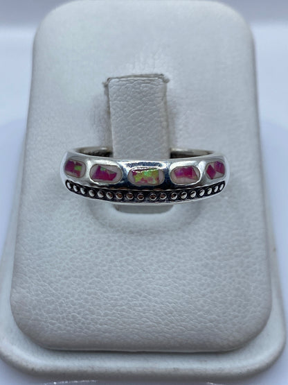Anillo de plata .950 con ópalo de fuego rosa engastado en los dedos de una mano