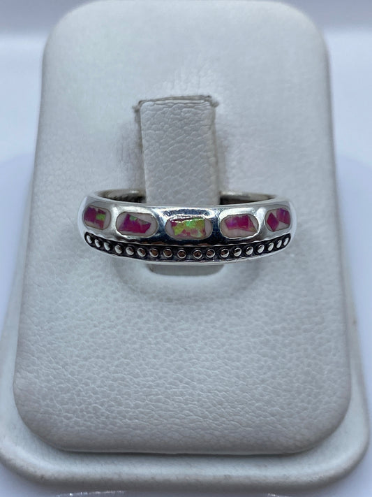 Anillo de plata .950 con ópalo de fuego rosa engastado en los dedos de una mano