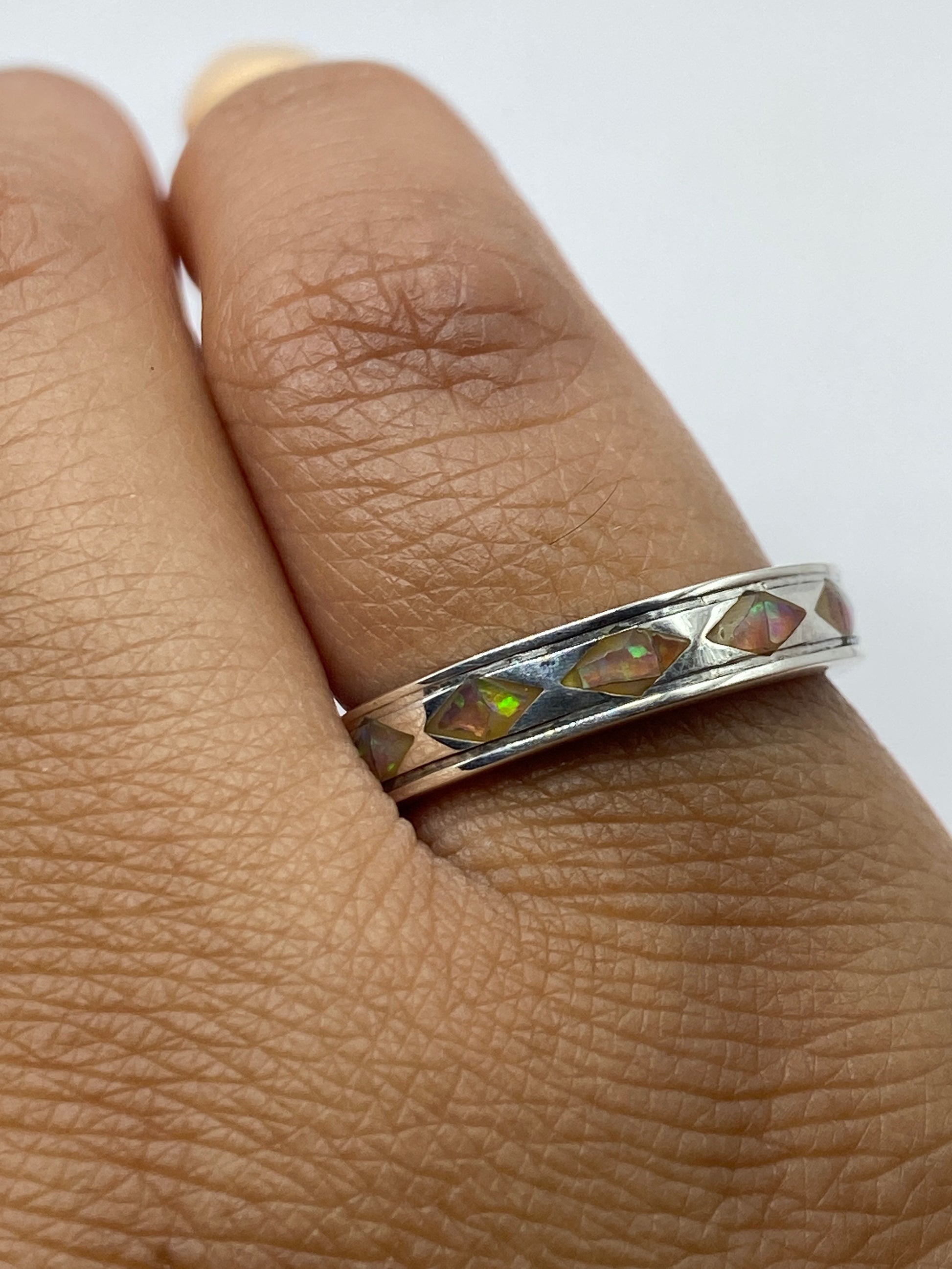 Anillo de plata .950 en la mano, mostrando el Quinto y el Ópalo
