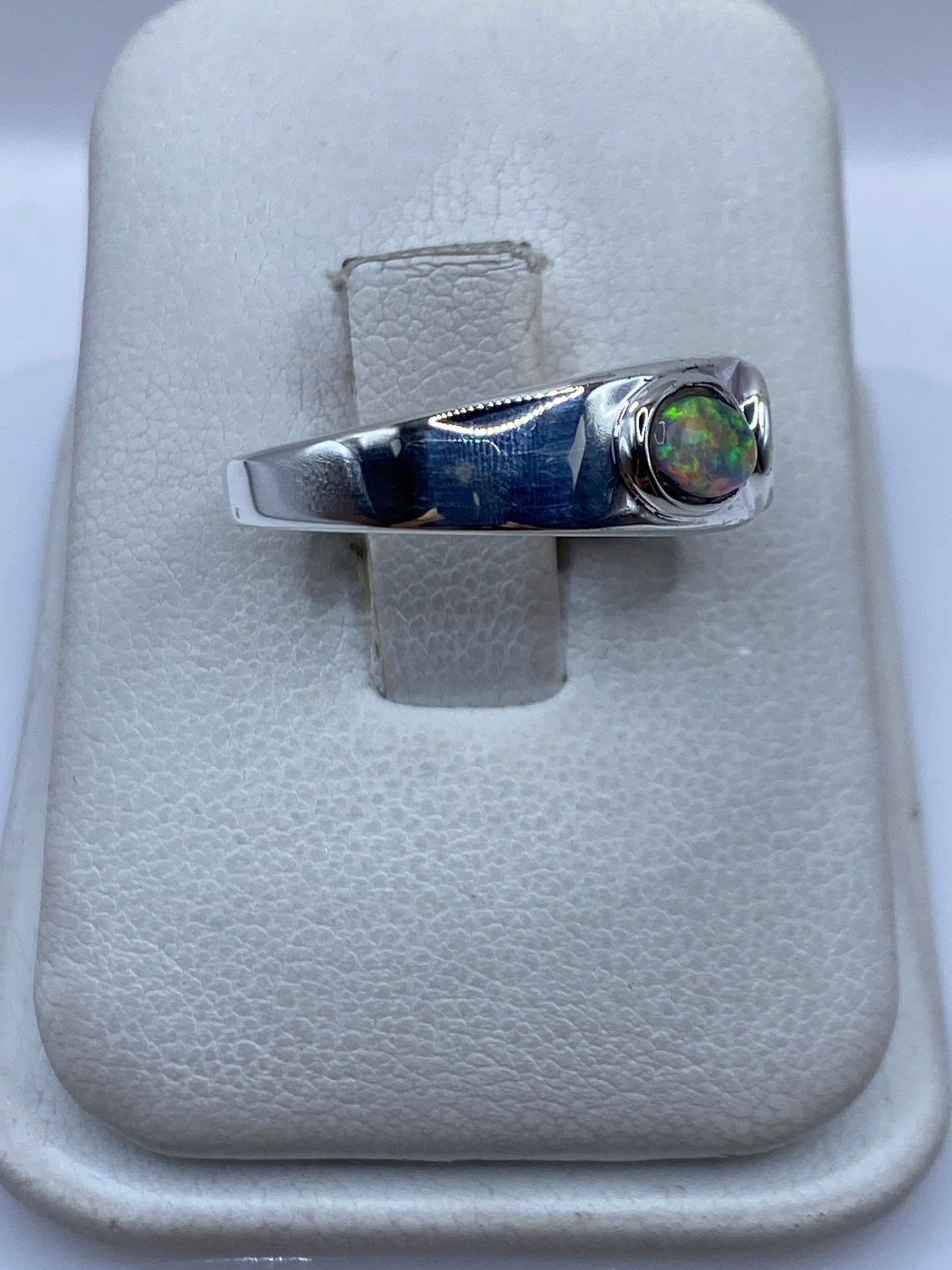 Anillo de plata .925 con ópalo de fuego iridiscente en vitrina blanca