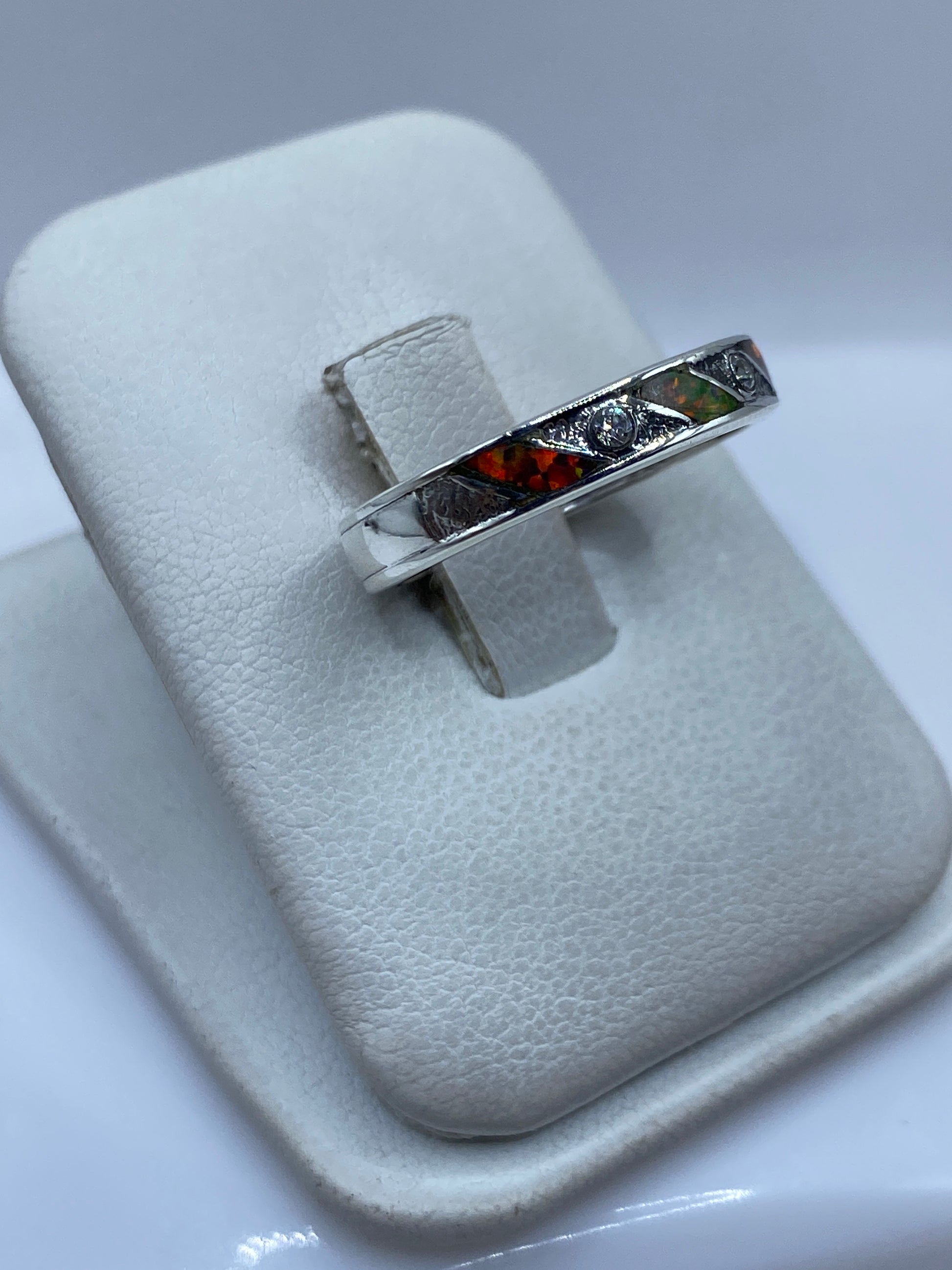 Detalle lateral del anillo mostrando el engaste a mano de la piedra en ópalo de fuego