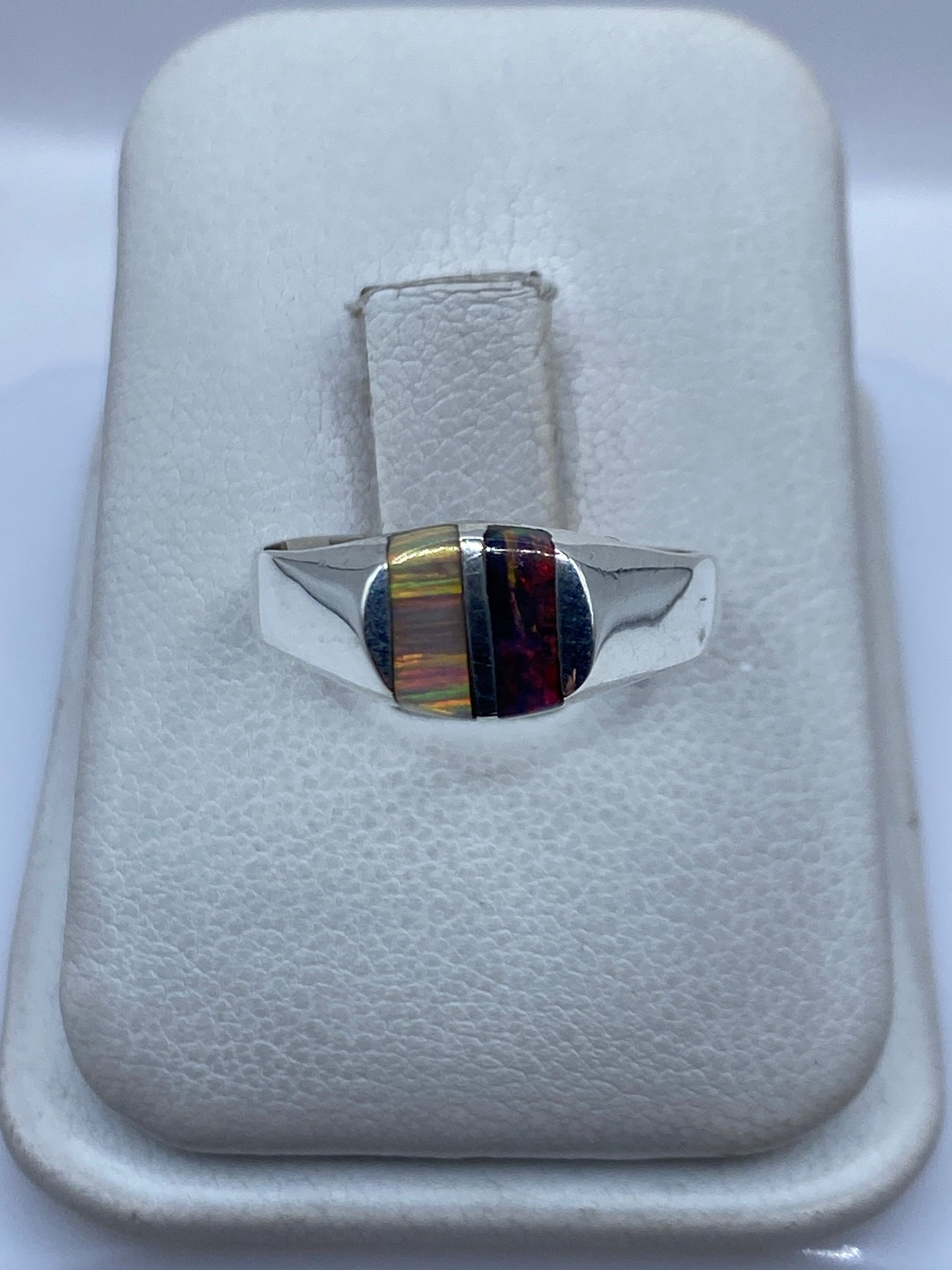 Anillo de plata con ópalo de fuego multicolor mostrando bandas de verde, naranja y rojo