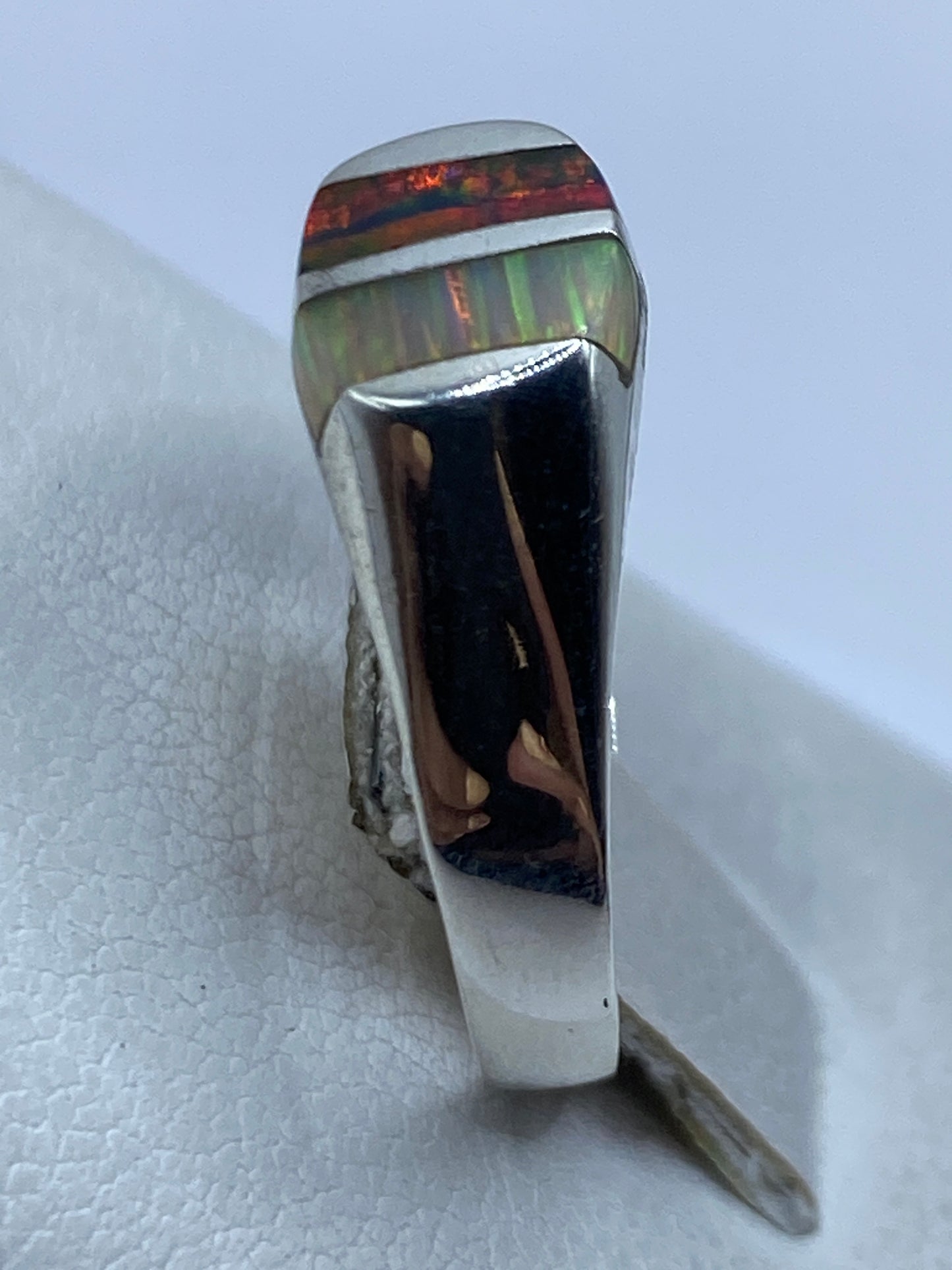 Anillo en la mano mostrando el brillo multicolor del ópalo de fuego