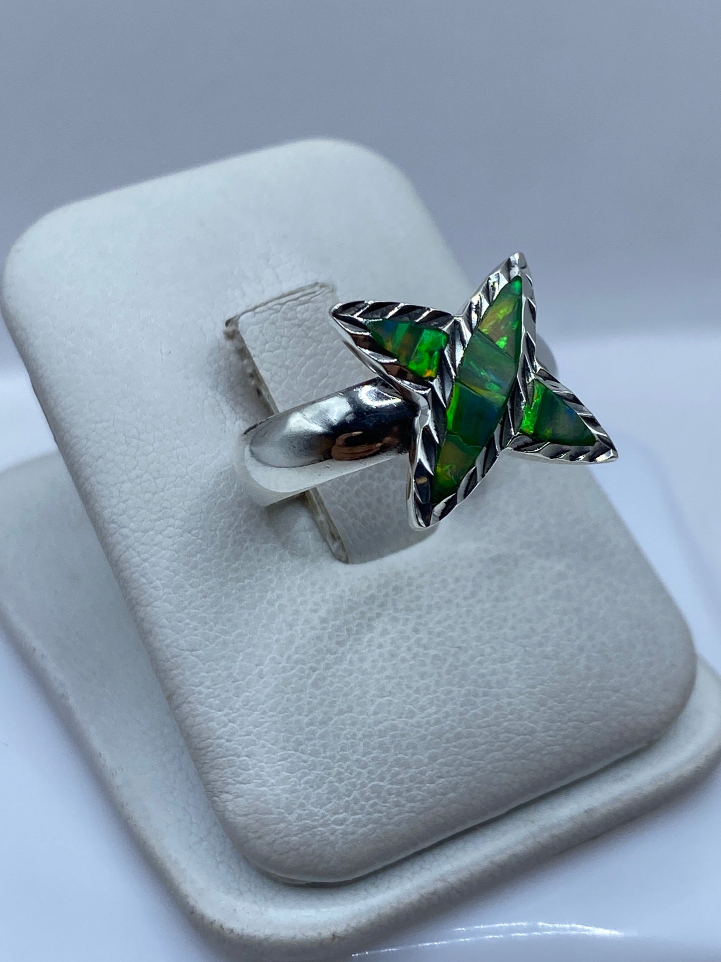 Detalle frontal del anillo mostrando el engaste a mano del opalo de fuego