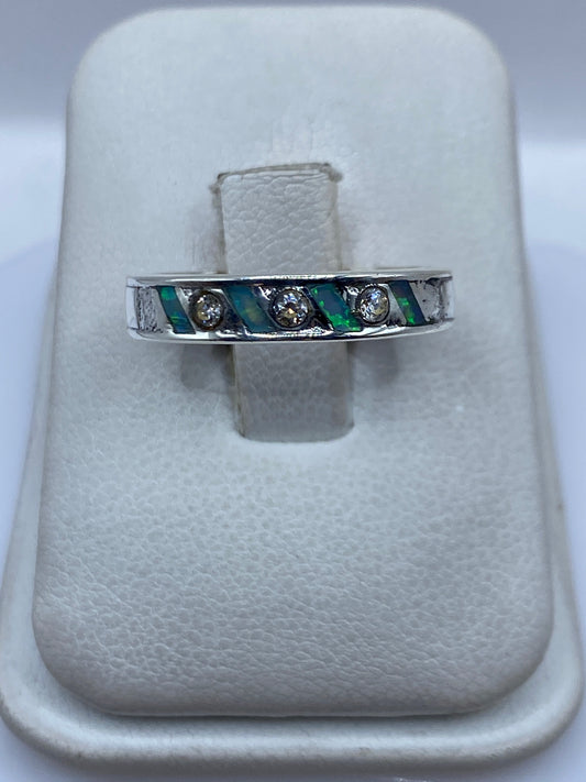 Anillo de plata .950 con Ópal de Fuego azul cielo, engastado en banda minimalista en la mano de una persona