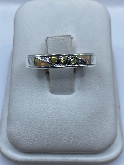 Anillo de plata .950 con ópalo de fuego multicolor en la mano, mostrando el juego de colores