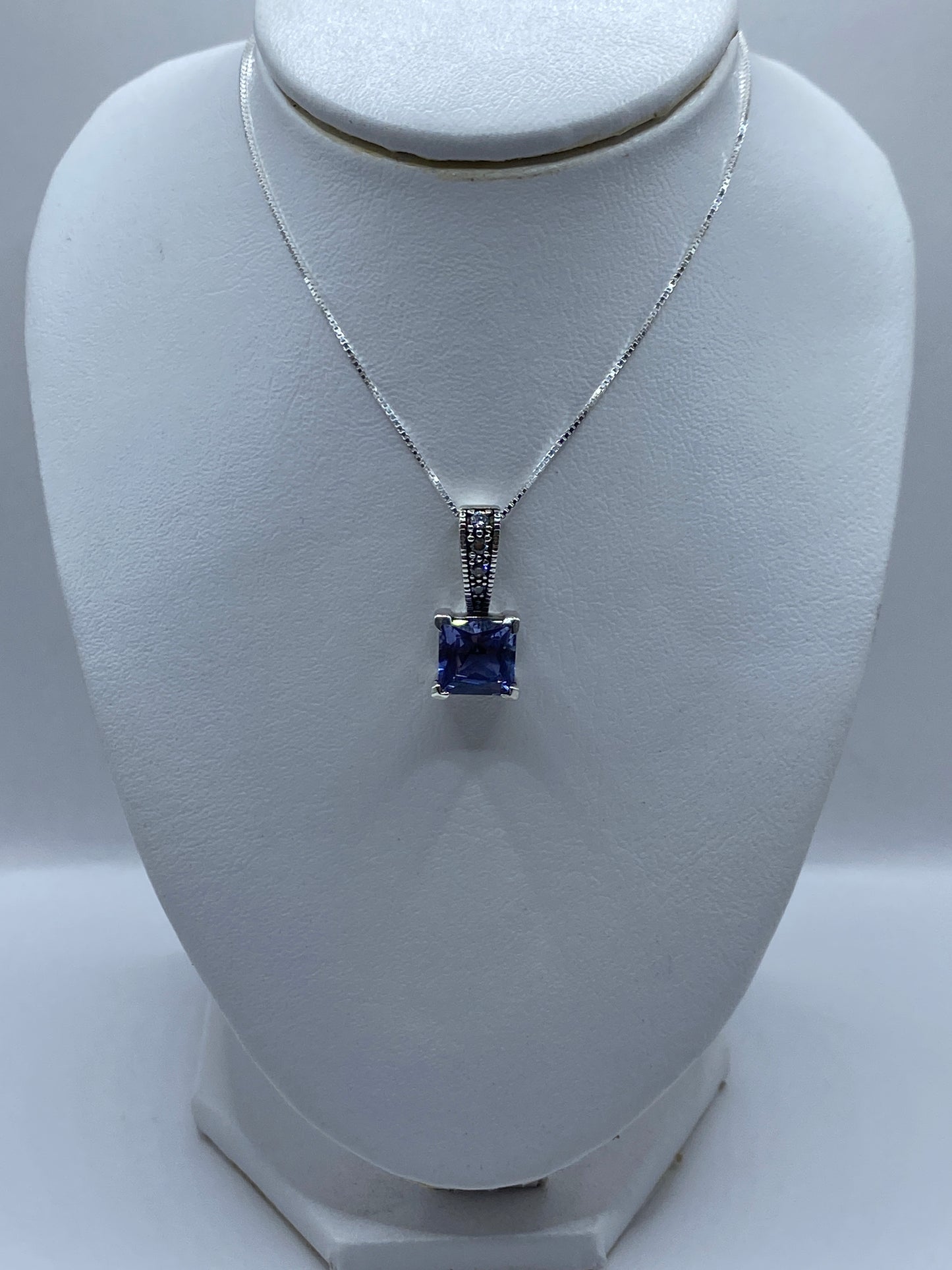 Detalle del dije mostrando la circonia talla brillante cuadrada lavanda y el engaste a mano
