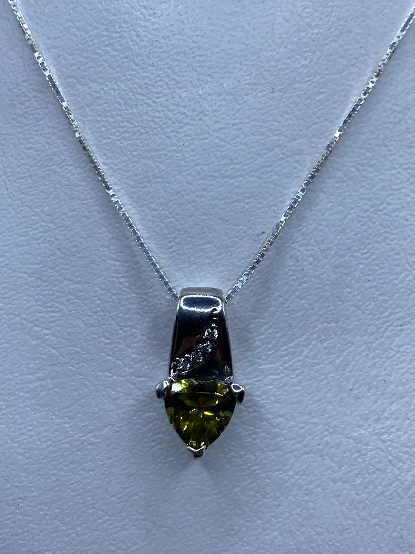Dije de plata con circonia verde olivo brillante sobre collar blanco