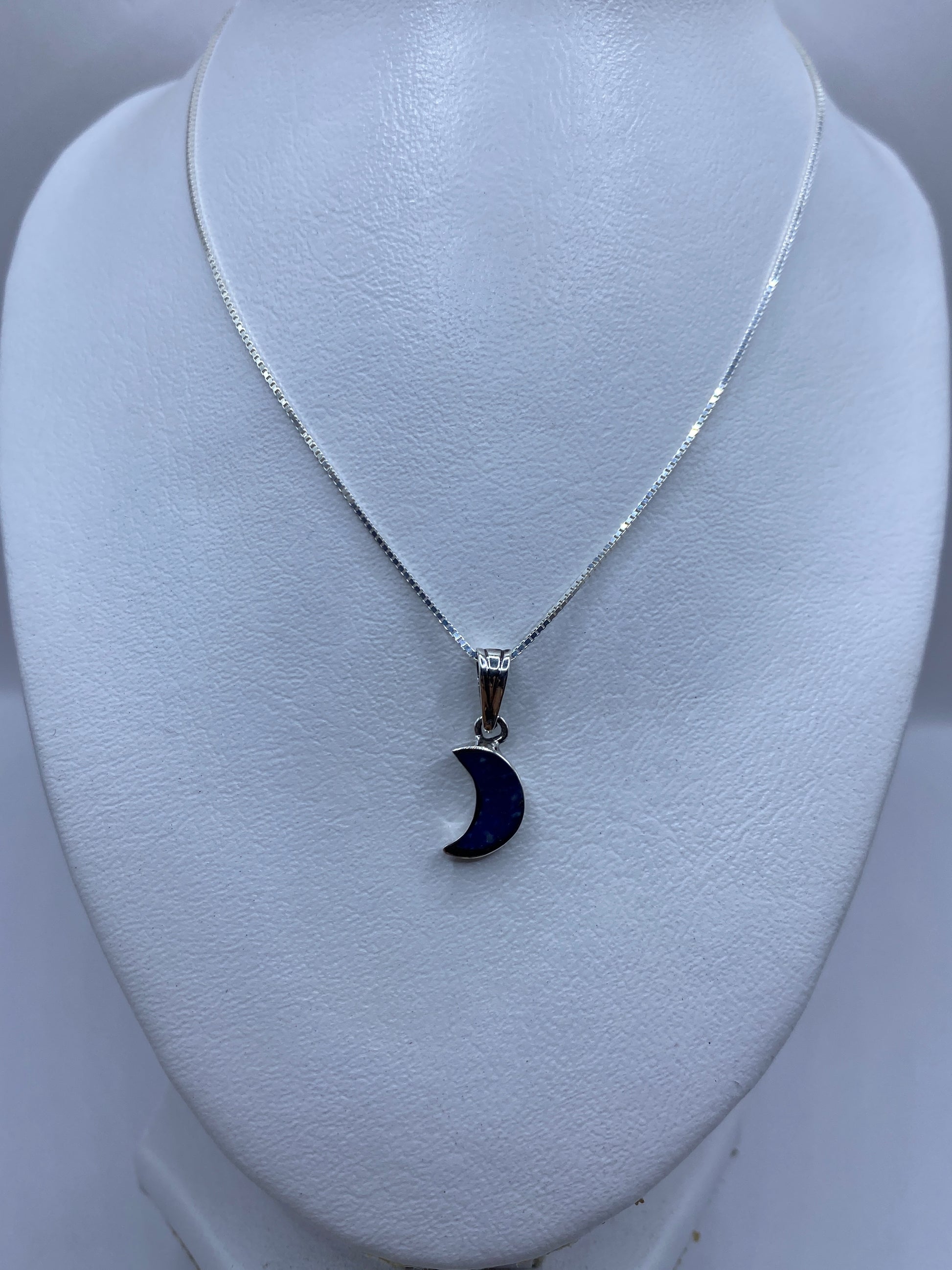 Dije miniatura en forma de luna con piedra azul — detalle del engaste a mano