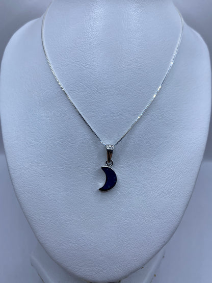 Dije miniatura en forma de luna con piedra azul — detalle del engaste a mano