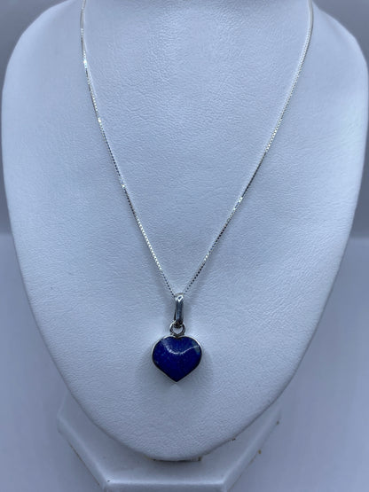 Dije de corazón en plata .950 mostrando el Quinto y la incrustación de piedra