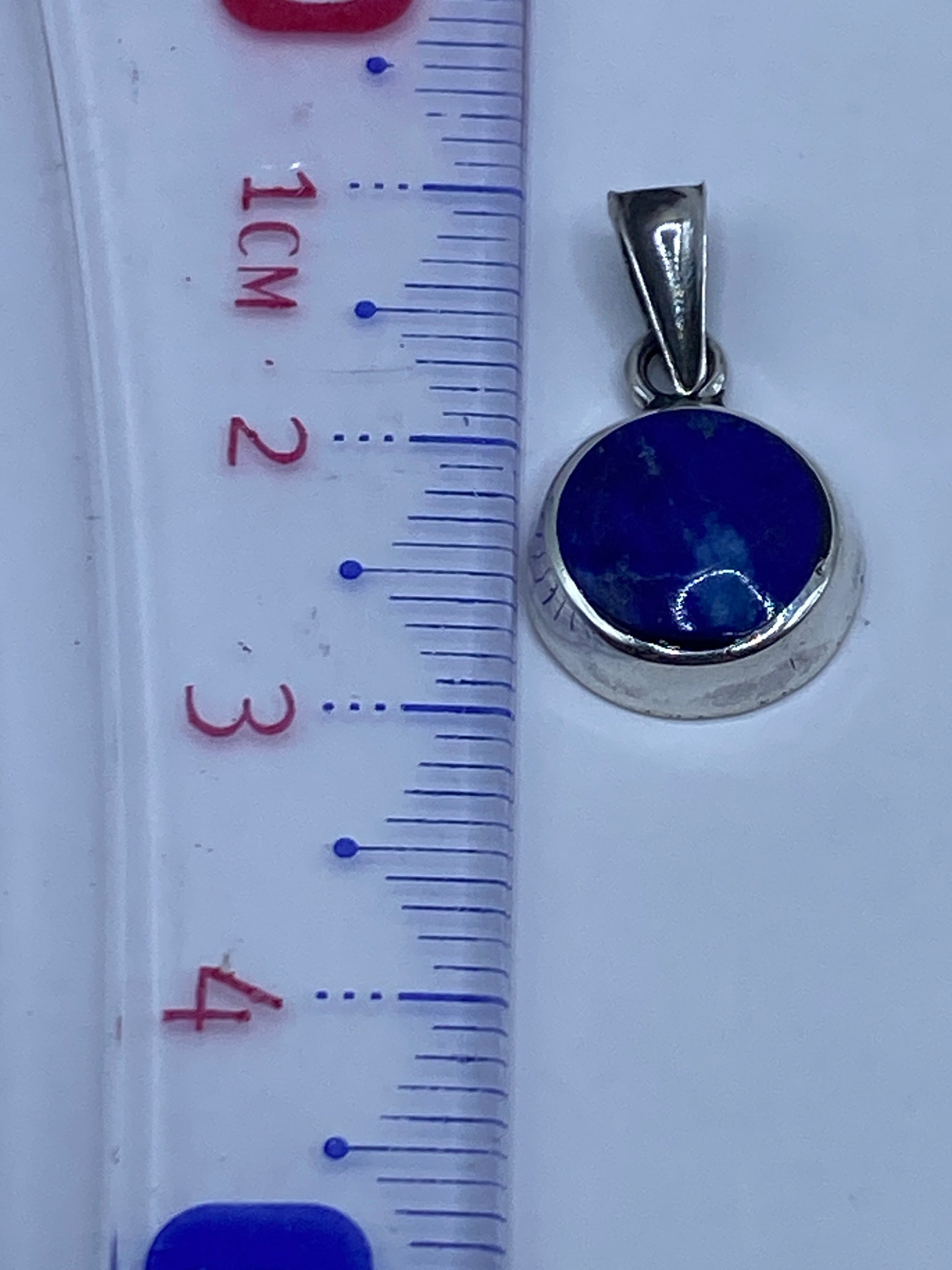 Dije medido en regla: diámetro aproximado 2.8 cm, peso 1.1 gramos