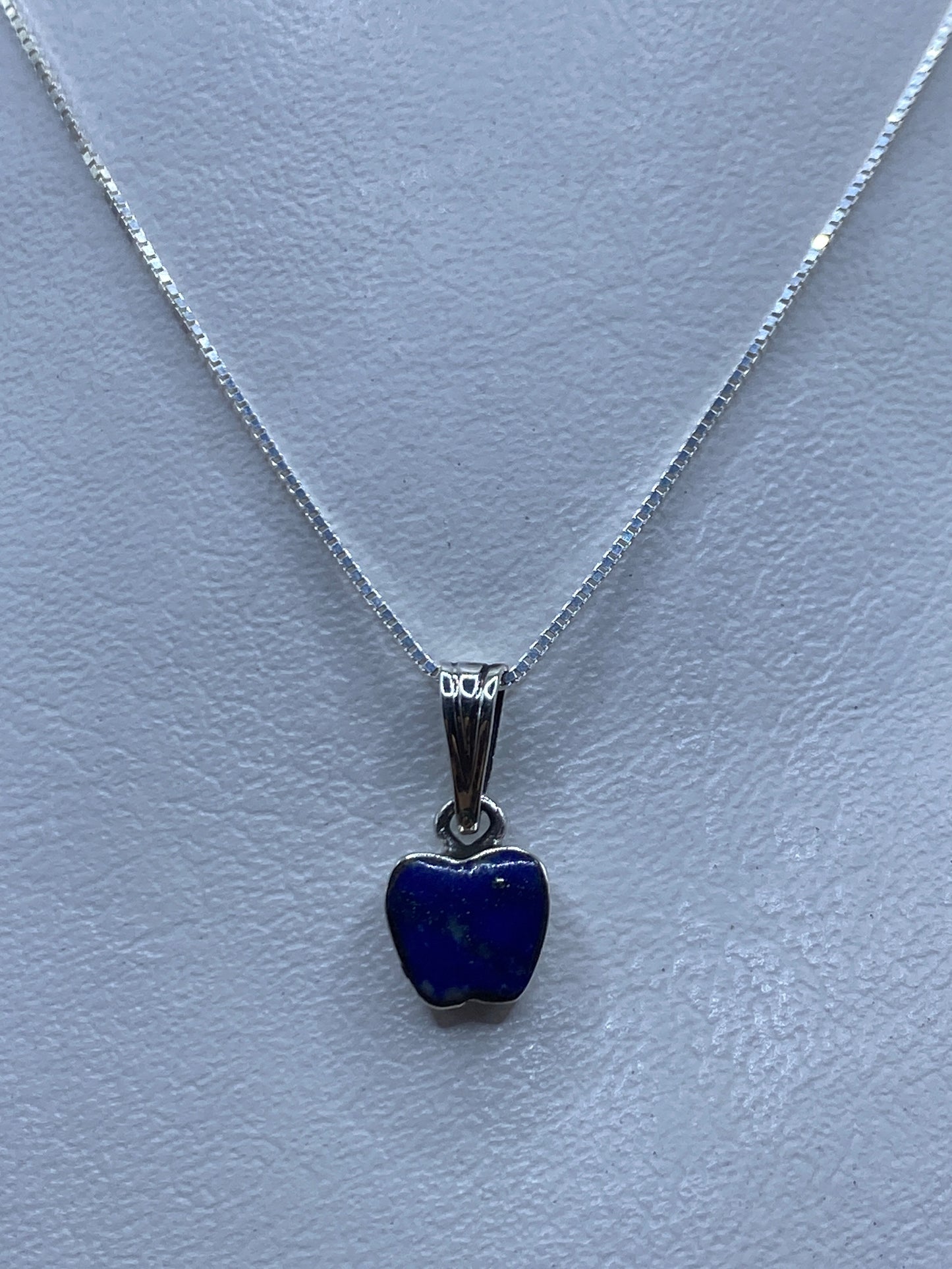 Dije de plata en forma de corazón con piedra azul, suspendido en cadena de plata