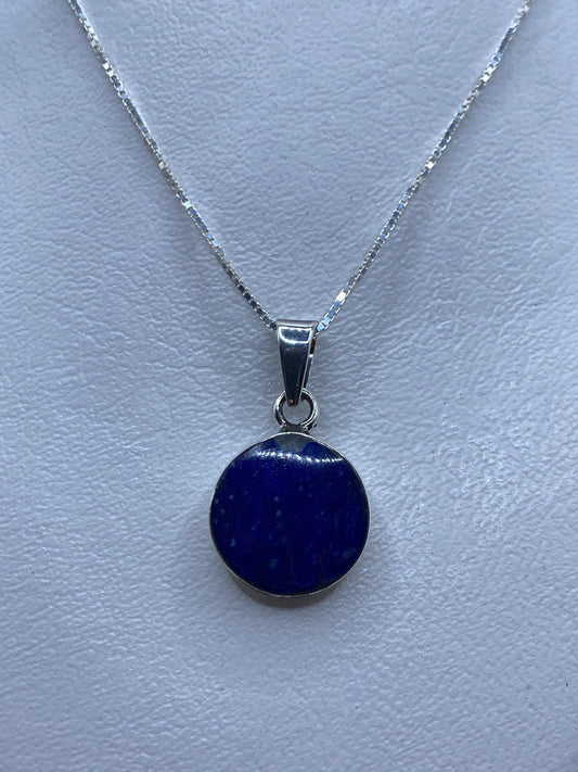 Dije de plata con piedra azul engastada a mano, sobre cadena plateada