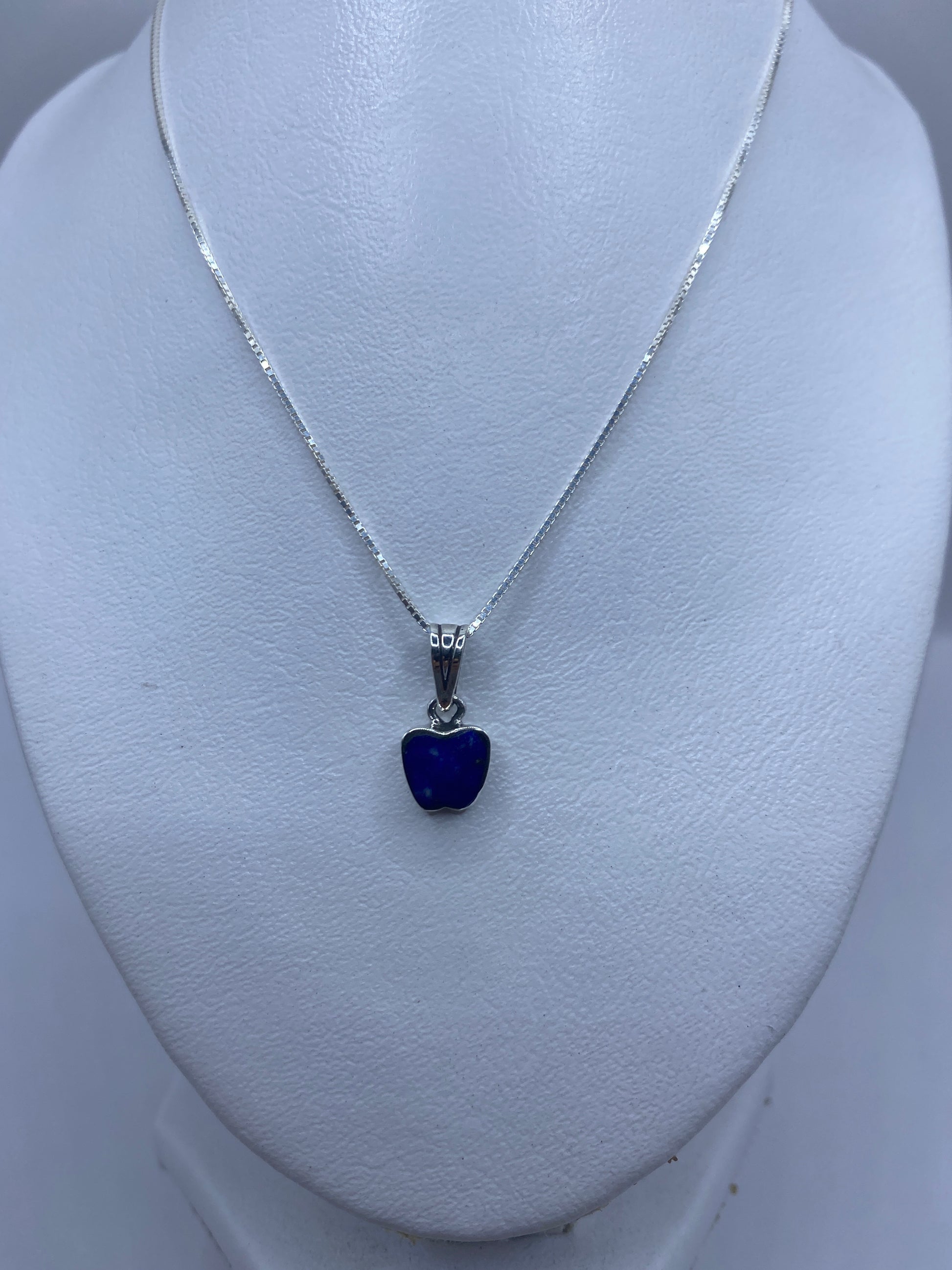 Detalle del dije mostrando el engaste de piedra azul en plata pulida
