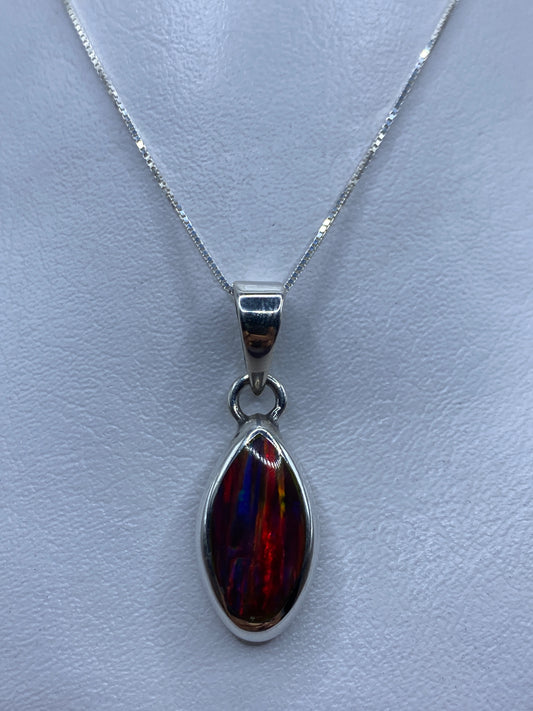 Dije de plata .950 con ópalo de fuego multicolor en tonos rojo, naranja y amarillo, colgado de una fina cadena de plata