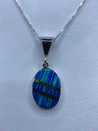 Dije de plata con ópalo de fuego azul, 4 cm, sobre fondo blanco