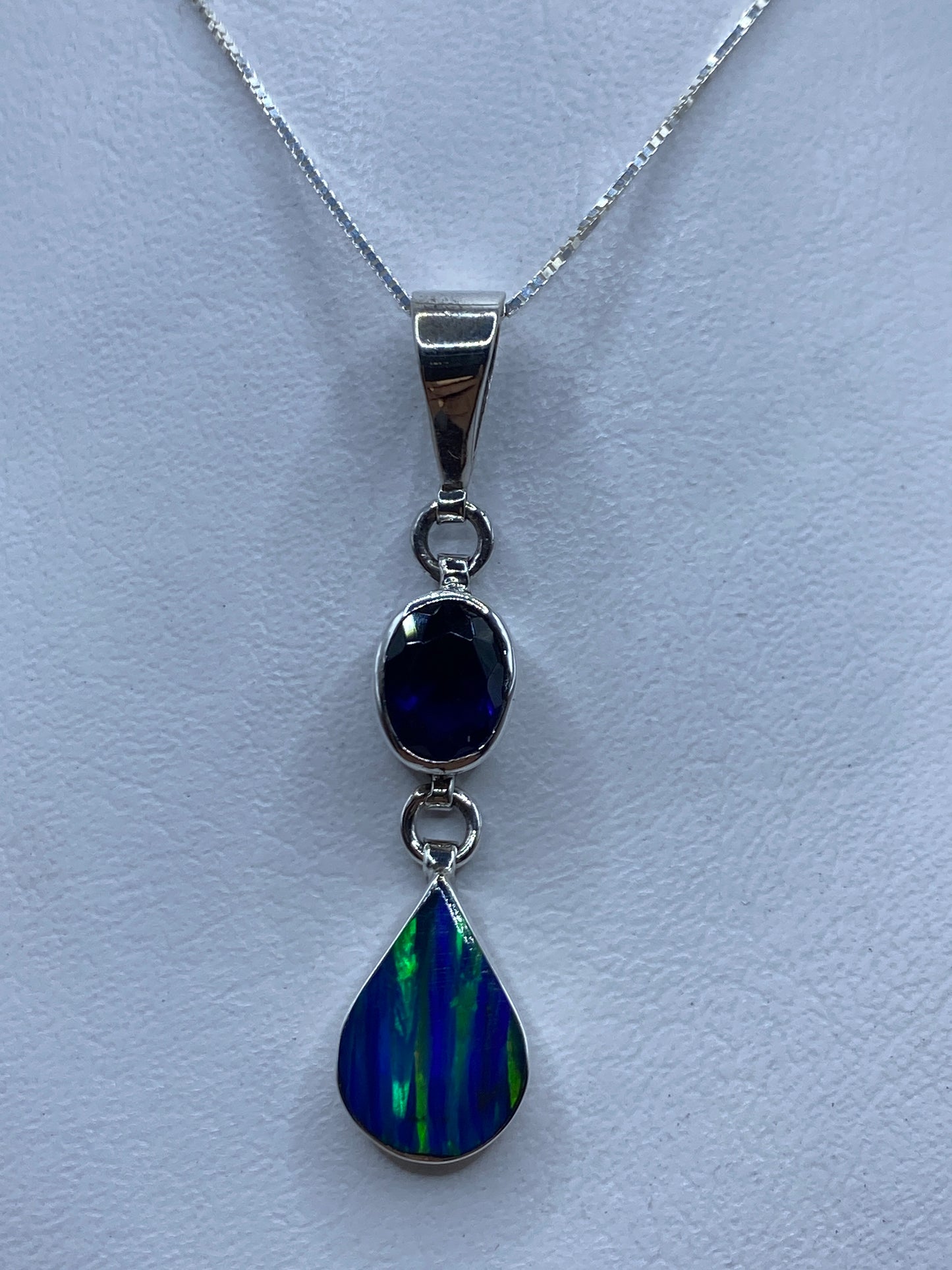 Dije de plata con ópalo de fuego azul colgando de una cadena de plata