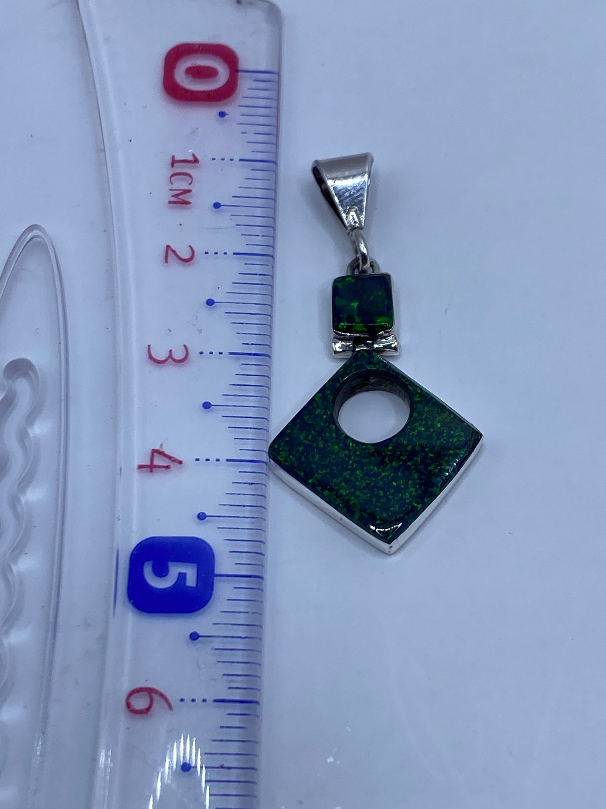 Reverso del dije de plata mostrando el Quinto 950 grabado y el acabado bruñido