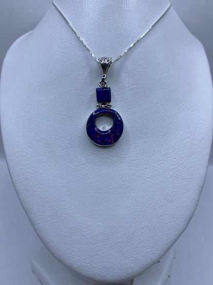 Detalle del ópalo de fuego azul engastado a mano en el dije de plata .950